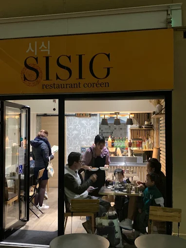 Devanture jaune moutarde du restaurant SISIG, rue Beauvoisine à Rouen, de nuit